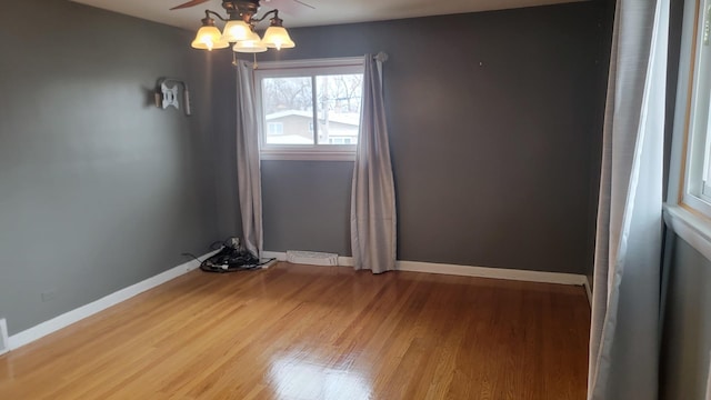 unfurnished room with hardwood / wood-style floors and a chandelier