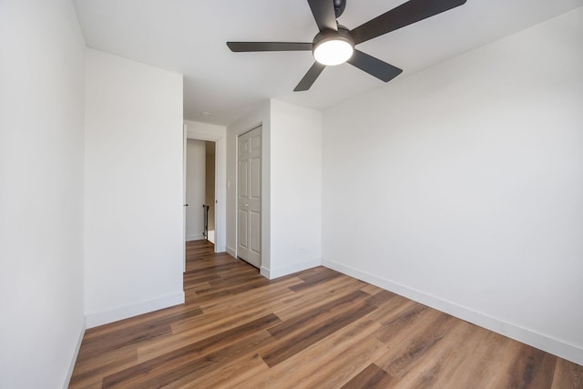 empty room featuring dark wood-type flooring and ceiling fan