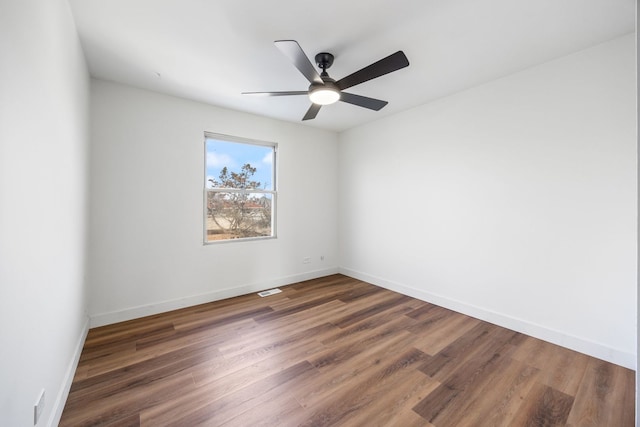 empty room with dark wood-type flooring and ceiling fan