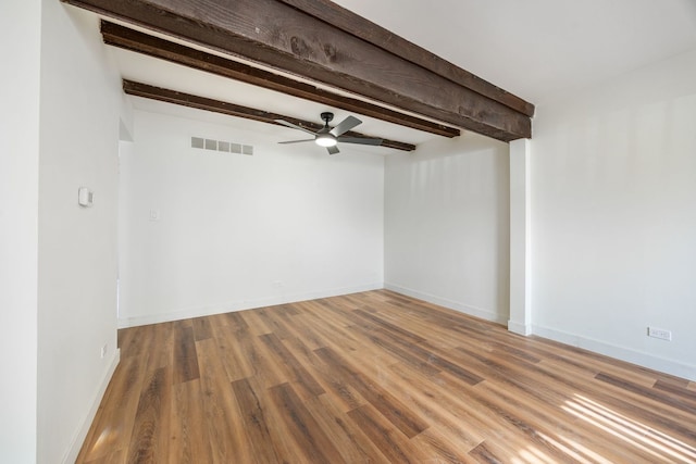 empty room featuring beamed ceiling, ceiling fan, and hardwood / wood-style floors