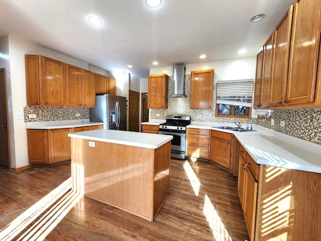 kitchen with sink, appliances with stainless steel finishes, dark hardwood / wood-style floors, a center island, and wall chimney exhaust hood