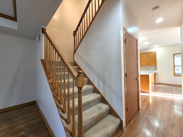 staircase with hardwood / wood-style flooring