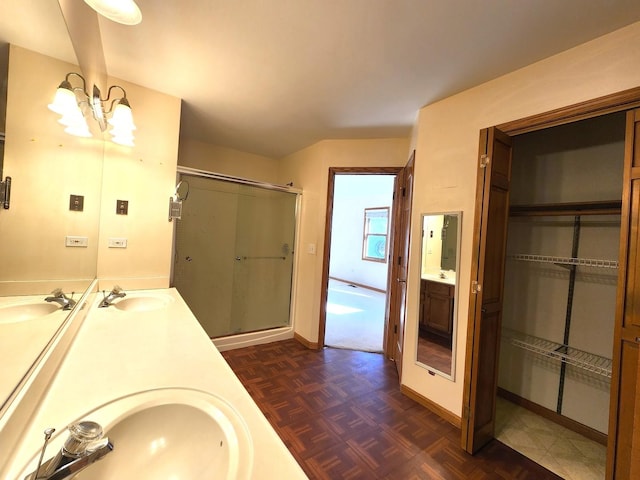 bathroom with parquet floors, vanity, walk in shower, and a notable chandelier