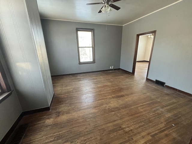 unfurnished room with ceiling fan, dark wood-type flooring, and crown molding