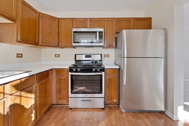 kitchen featuring stainless steel appliances, sink, and light hardwood / wood-style flooring