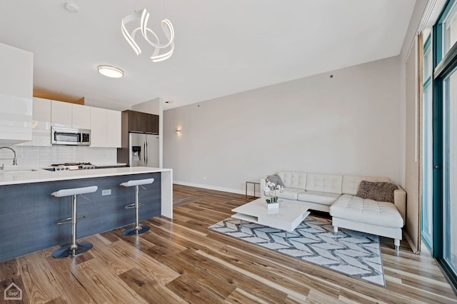 living room with sink, a wealth of natural light, and light hardwood / wood-style floors