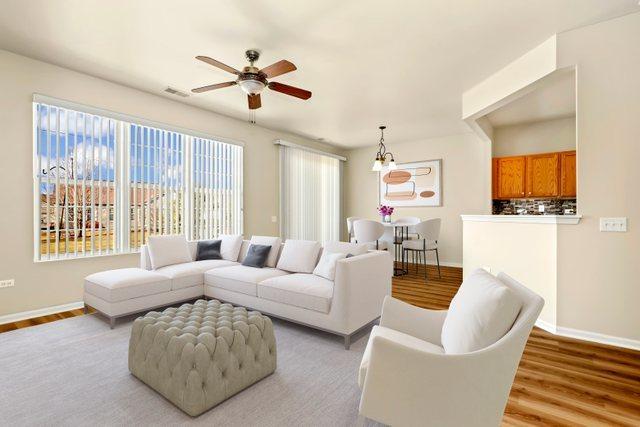 unfurnished living room with ceiling fan with notable chandelier and light hardwood / wood-style flooring