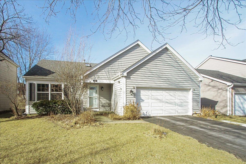 view of front of home with a garage and a front lawn