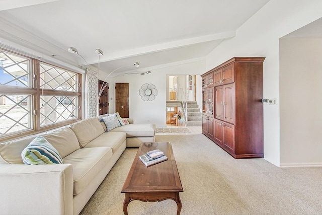 carpeted living room with lofted ceiling with beams