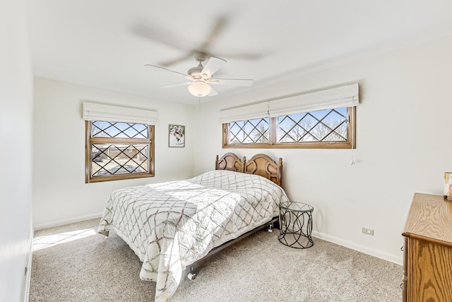 carpeted bedroom featuring ceiling fan and multiple windows