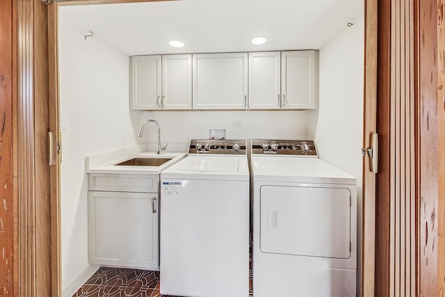 washroom featuring cabinets, sink, and washing machine and dryer