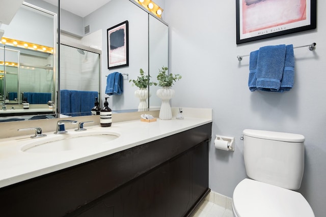 bathroom with vanity, an enclosed shower, and toilet