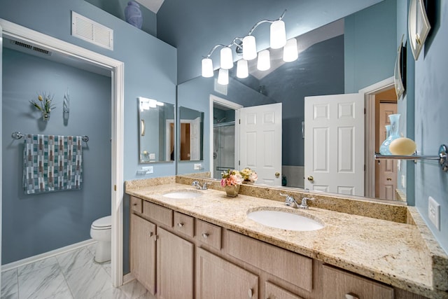 bathroom featuring a shower with door, toilet, and vanity