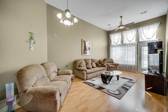 living room with light wood-type flooring and ceiling fan with notable chandelier