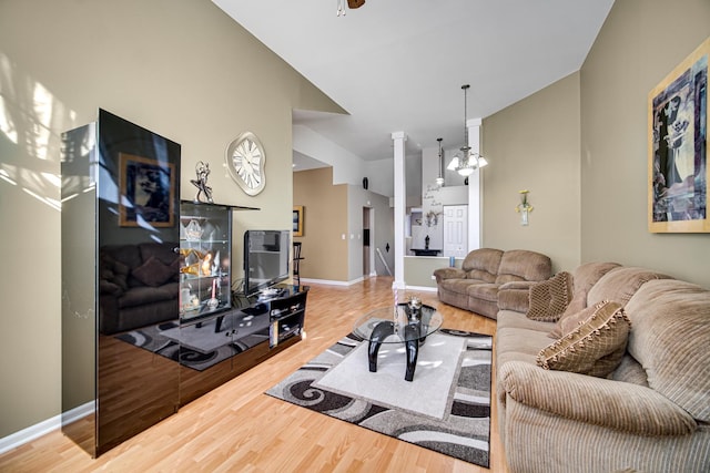 living room with an inviting chandelier, lofted ceiling, and wood-type flooring