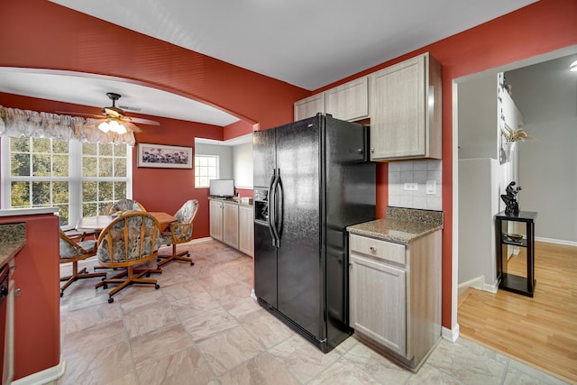 kitchen featuring light brown cabinets, backsplash, black refrigerator with ice dispenser, and ceiling fan