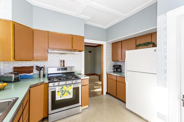 kitchen featuring sink, backsplash, stainless steel range with gas cooktop, and white fridge