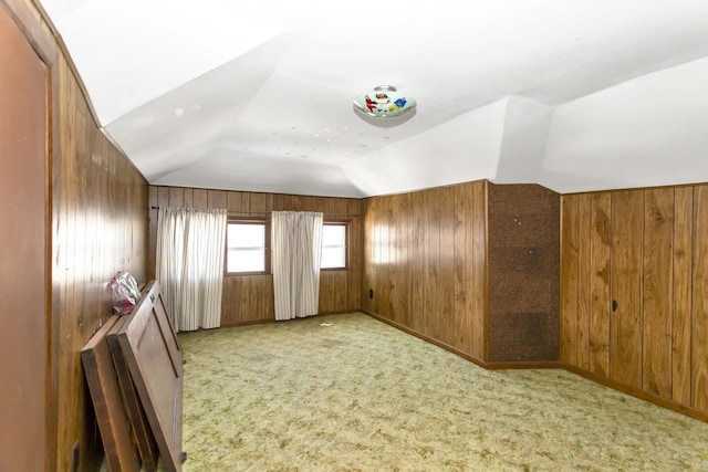 bonus room featuring lofted ceiling, light colored carpet, and wood walls