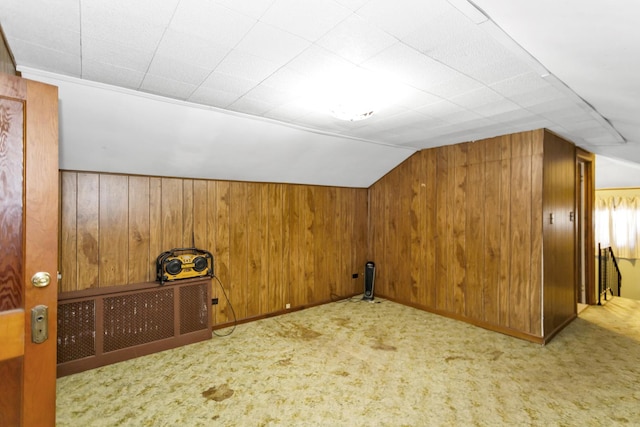 bonus room with light colored carpet, wooden walls, and vaulted ceiling