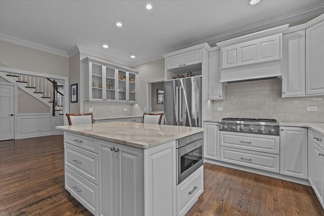 kitchen with dark wood-type flooring, light stone countertops, white cabinets, and appliances with stainless steel finishes