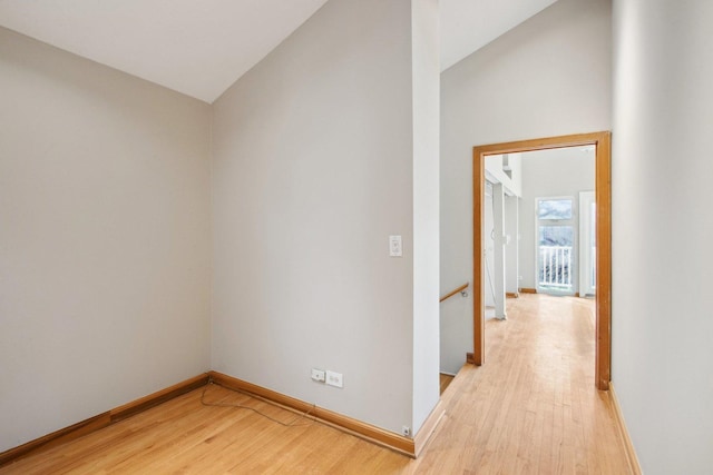 corridor featuring lofted ceiling and light wood-type flooring