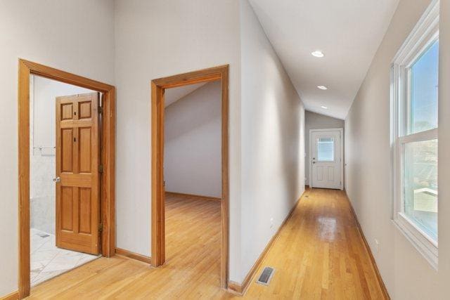 hallway featuring light hardwood / wood-style flooring and vaulted ceiling