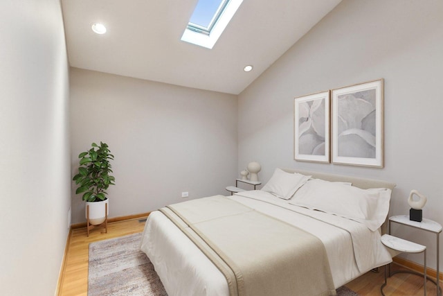 bedroom with wood-type flooring and lofted ceiling with skylight