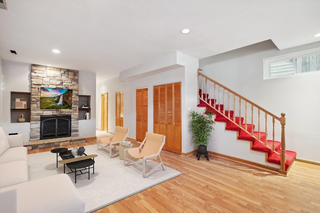 living room featuring a stone fireplace and hardwood / wood-style floors