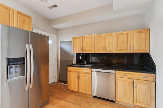 kitchen with sink, backsplash, stainless steel appliances, light brown cabinets, and light wood-type flooring