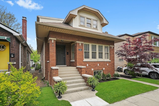 bungalow-style house featuring brick siding and a front lawn
