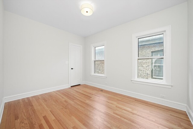 unfurnished room featuring baseboards and light wood-style floors