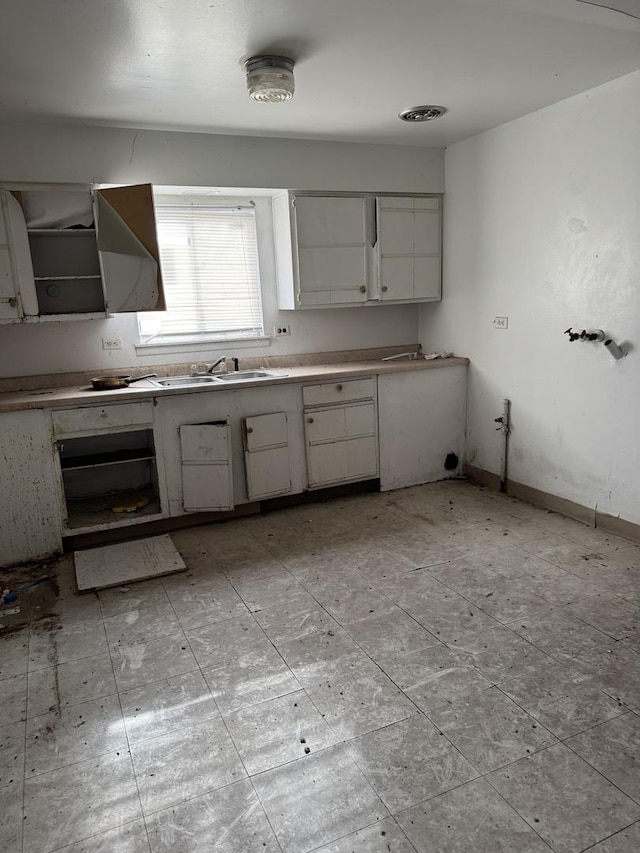 kitchen featuring white cabinetry and sink