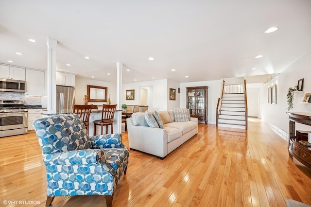 living room featuring decorative columns and light wood-type flooring