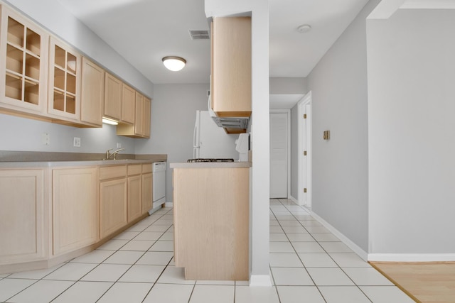 kitchen with sink, white appliances, light brown cabinetry, and light tile patterned flooring