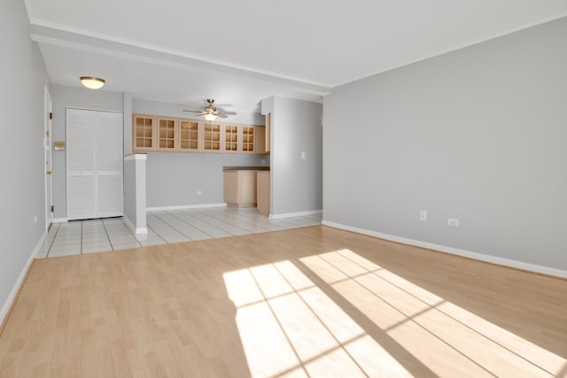 unfurnished living room featuring light wood-type flooring and ceiling fan