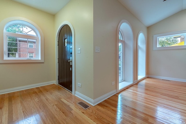 foyer with lofted ceiling and light wood-type flooring