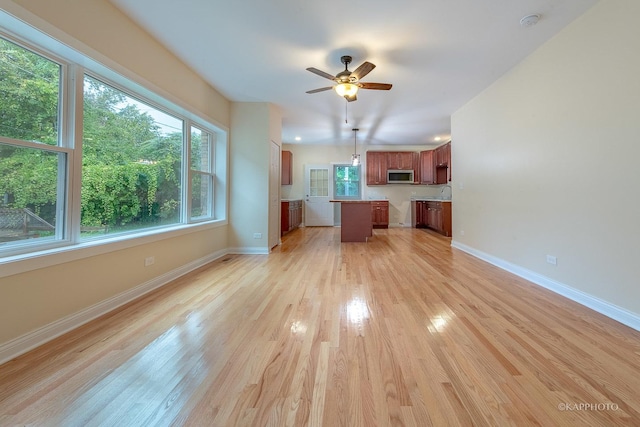 unfurnished living room with ceiling fan and light wood-type flooring