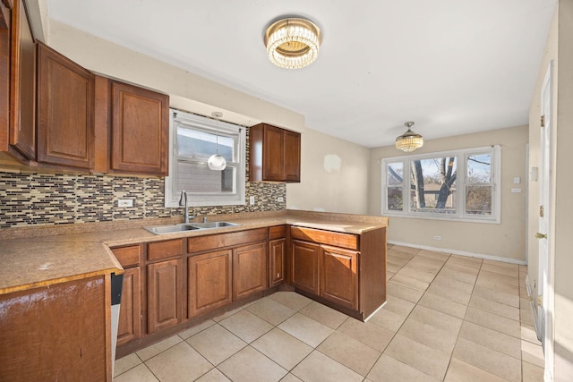 kitchen with sink, backsplash, kitchen peninsula, and light tile patterned floors