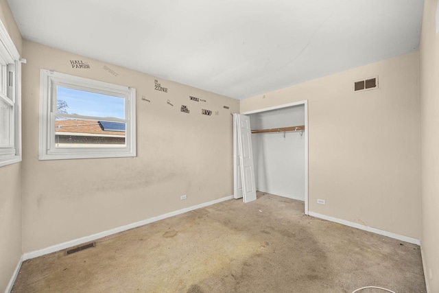 unfurnished bedroom featuring a closet and light colored carpet