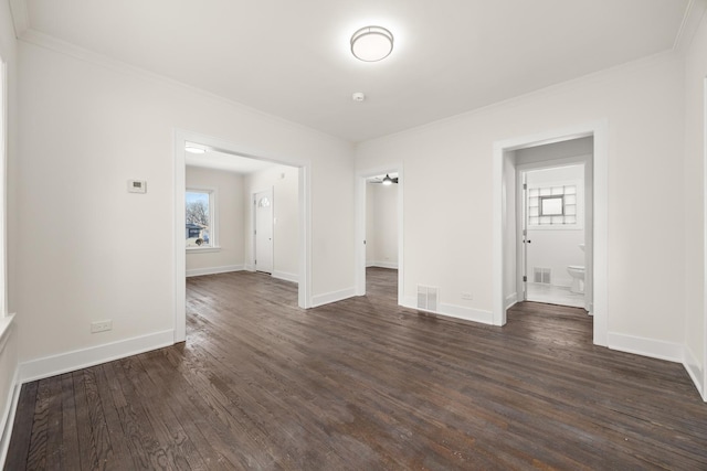 empty room featuring dark wood-type flooring, crown molding, and a wealth of natural light