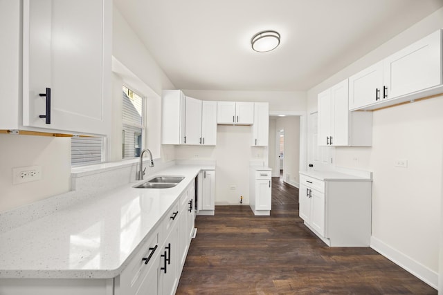 kitchen with dark hardwood / wood-style flooring, sink, white cabinets, and light stone counters