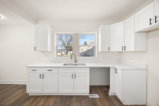 kitchen with dark hardwood / wood-style floors, sink, and white cabinets