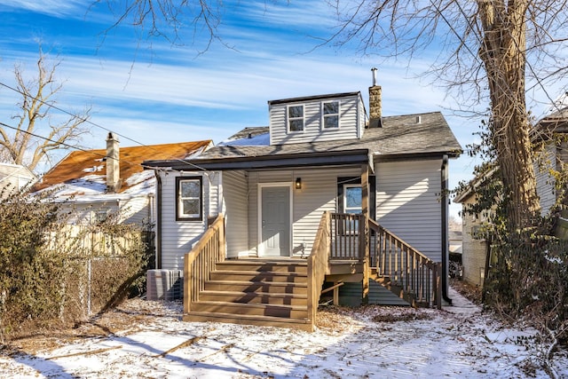 snow covered house with central AC unit