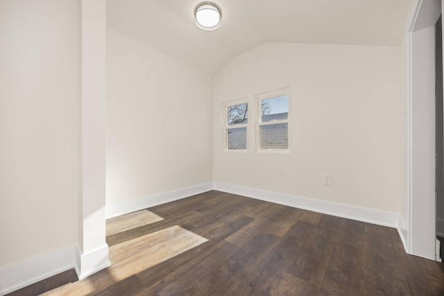 unfurnished room with dark wood-type flooring and vaulted ceiling