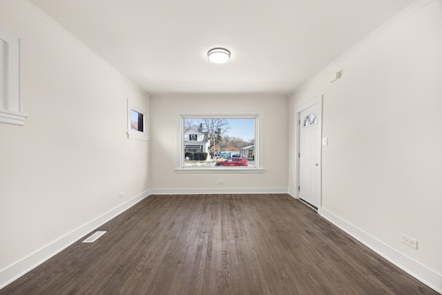 empty room with crown molding and dark hardwood / wood-style floors