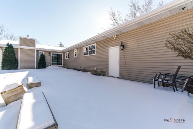 view of snow covered back of property