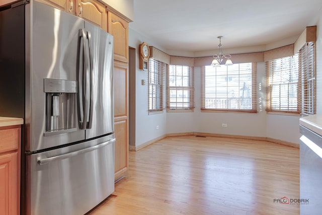 kitchen with stainless steel fridge with ice dispenser, a wealth of natural light, light hardwood / wood-style floors, and hanging light fixtures