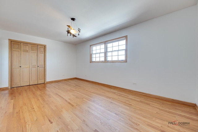 unfurnished bedroom featuring light hardwood / wood-style floors and a closet