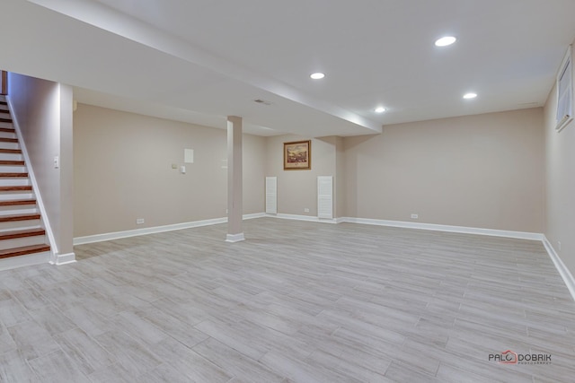 basement with light hardwood / wood-style flooring