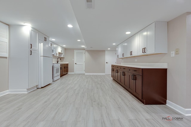 kitchen featuring sink, dark brown cabinets, white appliances, light hardwood / wood-style floors, and white cabinets